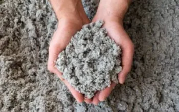 Two hands holding attic insulation